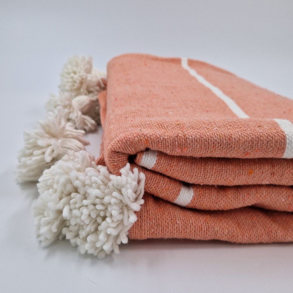 Handmade coral pink Moroccan Pompom blanket with white stripes and white pompoms