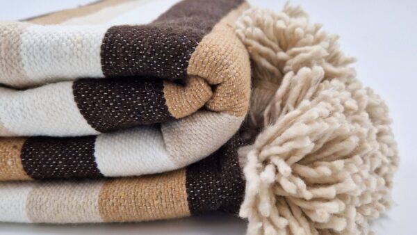 Moroccan Handwoven Blanket with four shared of brown in zebra style with beige pom poms on the edges