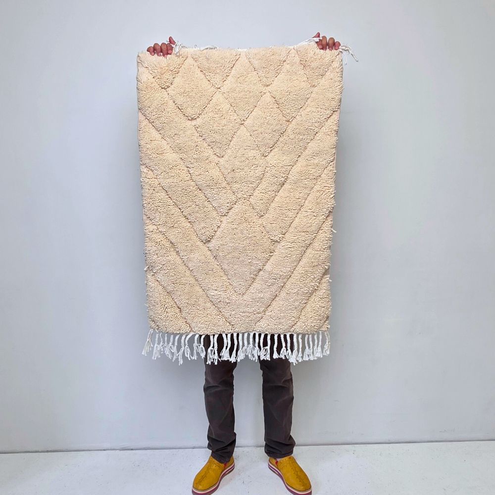 Minimalistic Moroccan Azilal rug with bold geometric patterns in white wool, featuring abstract Berber tribal motifs and handwoven texture.