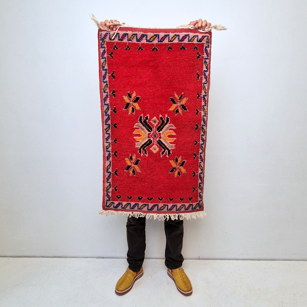 Bohemian Moroccan Azilal rug with bold geometric patterns in red, blue, white and multicolor wool, featuring abstract Berber tribal motifs and handwoven texture.