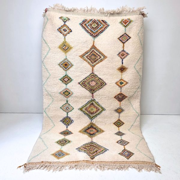 Colorful Moroccan Beni Ourain rug with blue, brown, red, black geometric patterns featuring abstract Berber tribal motifs and handwoven texture.