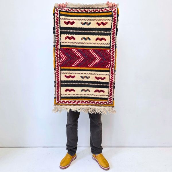 Colorful Moroccan Azilal rug with bold geometric patterns in red, orange, purple, and multicolor wool, featuring abstract Berber tribal motifs and handwoven texture.