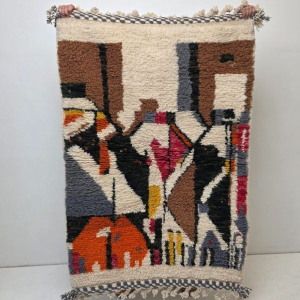 Colorful Moroccan Beni Ourain rug with blue, brown, red, black geometric patterns featuring abstract Berber tribal motifs and handwoven texture.