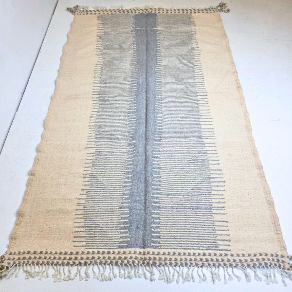 Minimalistic Moroccan Azilal rug with bold geometric patterns in white and blue wool, featuring abstract Berber tribal motifs and handwoven texture.