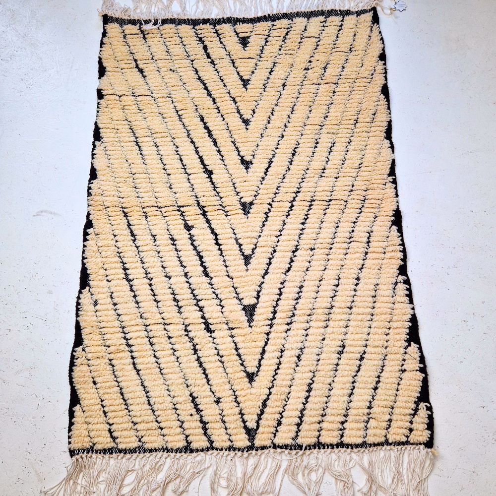 Minimalistic Moroccan Azilal rug with bold geometric patterns in white and black wool, featuring abstract Berber tribal motifs and handwoven texture.