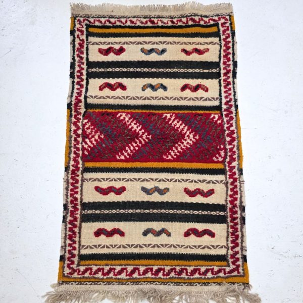 Colorful Moroccan Azilal rug with bold geometric patterns in red, orange, purple, and multicolor wool, featuring abstract Berber tribal motifs and handwoven texture.