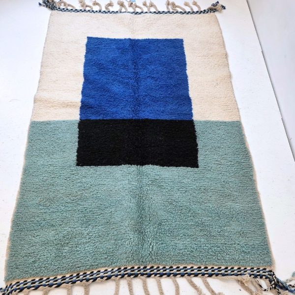 Colorful Moroccan Beni Ourain rug with blue, black and mint geometric patterns featuring abstract Berber tribal motifs and handwoven texture.