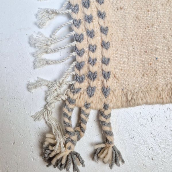 Minimalistic Moroccan Azilal rug with bold geometric patterns in white and blue wool, featuring abstract Berber tribal motifs and handwoven texture.