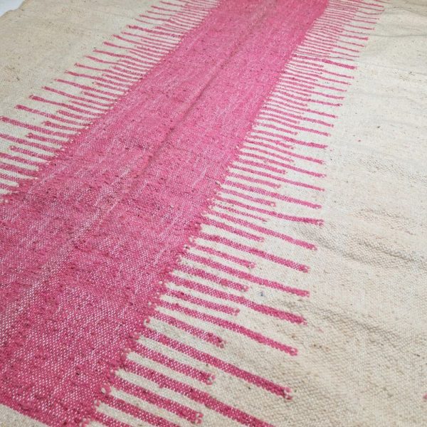 Minimalistic Moroccan Azilal rug with bold geometric patterns in white and pink wool, featuring abstract Berber tribal motifs and handwoven texture.
