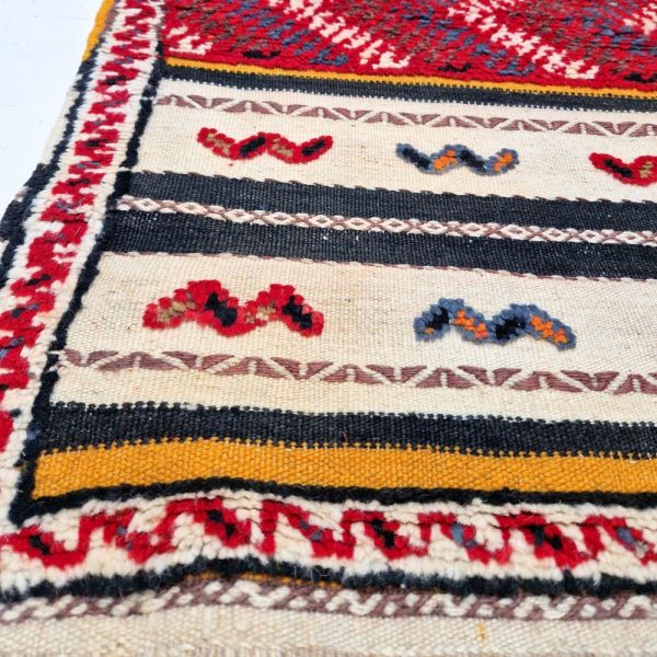 Colorful Moroccan Azilal rug with bold geometric patterns in red, orange, purple, and multicolor wool, featuring abstract Berber tribal motifs and handwoven texture.