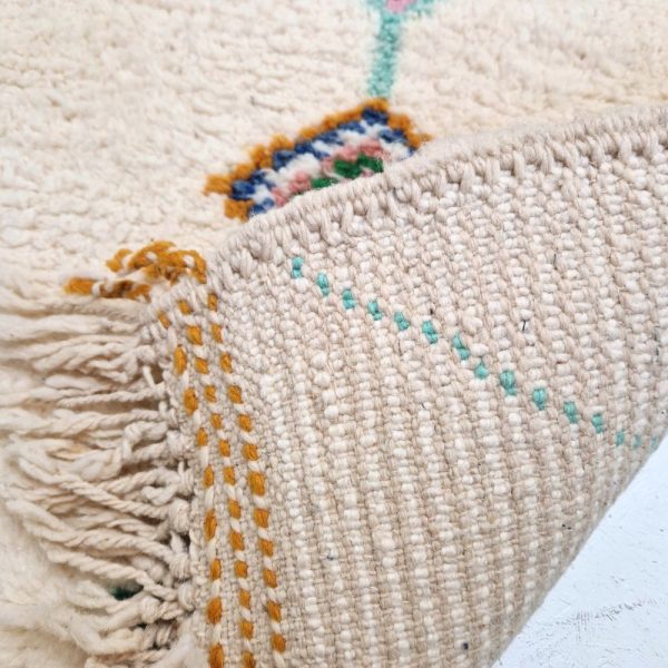 Colorful Moroccan Beni Ourain rug with blue, brown, red, black geometric patterns featuring abstract Berber tribal motifs and handwoven texture.