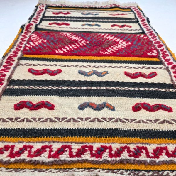 Colorful Moroccan Azilal rug with bold geometric patterns in red, orange, purple, and multicolor wool, featuring abstract Berber tribal motifs and handwoven texture.