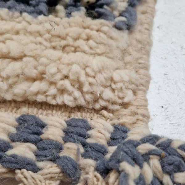 Colorful Moroccan Beni Ourain rug with blue, brown, red, black geometric patterns featuring abstract Berber tribal motifs and handwoven texture.