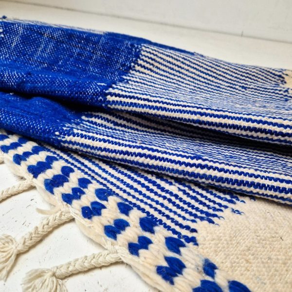 Minimalistic Moroccan Azilal rug with bold geometric patterns in white and blue wool, featuring abstract Berber tribal motifs and handwoven texture.