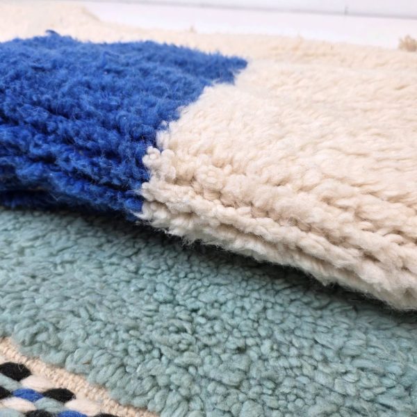 Colorful Moroccan Beni Ourain rug with blue, black and mint geometric patterns featuring abstract Berber tribal motifs and handwoven texture.