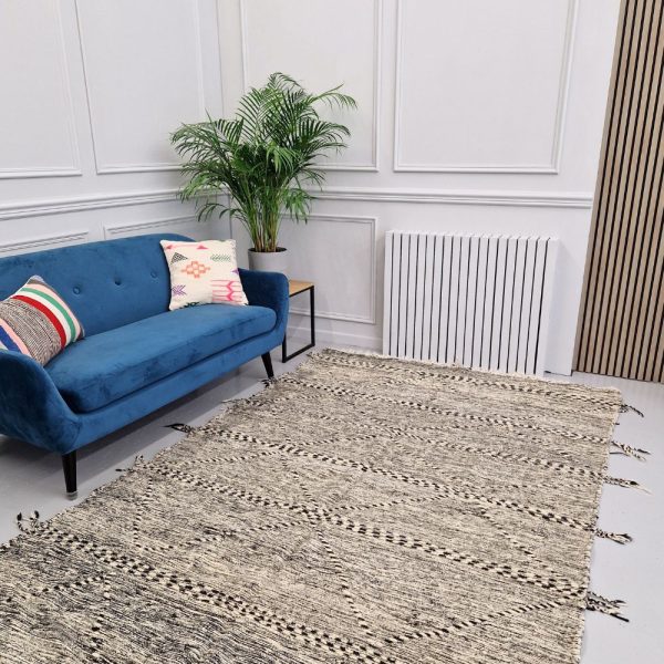 Minimalistic Moroccan Azilal rug with bold geometric patterns in white and black wool, featuring abstract Berber tribal motifs and handwoven texture.