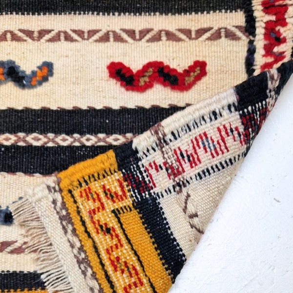 Colorful Moroccan Azilal rug with bold geometric patterns in red, orange, purple, and multicolor wool, featuring abstract Berber tribal motifs and handwoven texture.