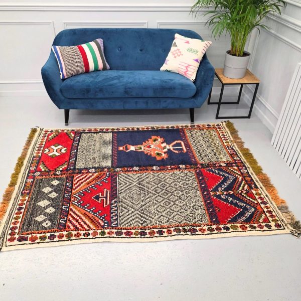 Colorful Moroccan Azilal rug with bold geometric patterns in red, blue, black, and multicolor wool, featuring abstract Berber tribal motifs and handwoven texture.