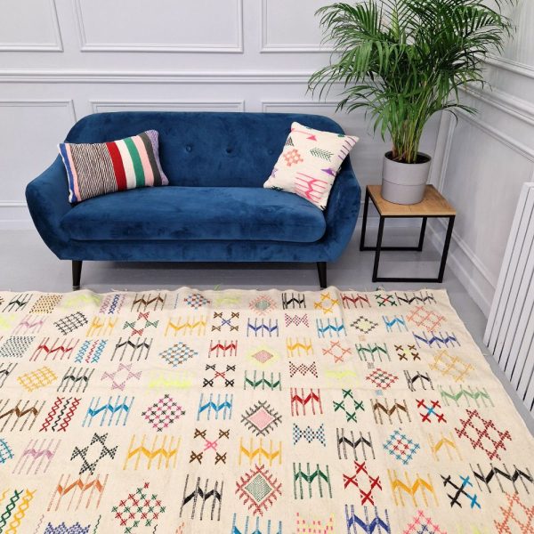 Colorful Moroccan Azilal rug with bold geometric patterns in red, orange, purple, and multicolor wool, featuring abstract Berber tribal motifs and handwoven texture.