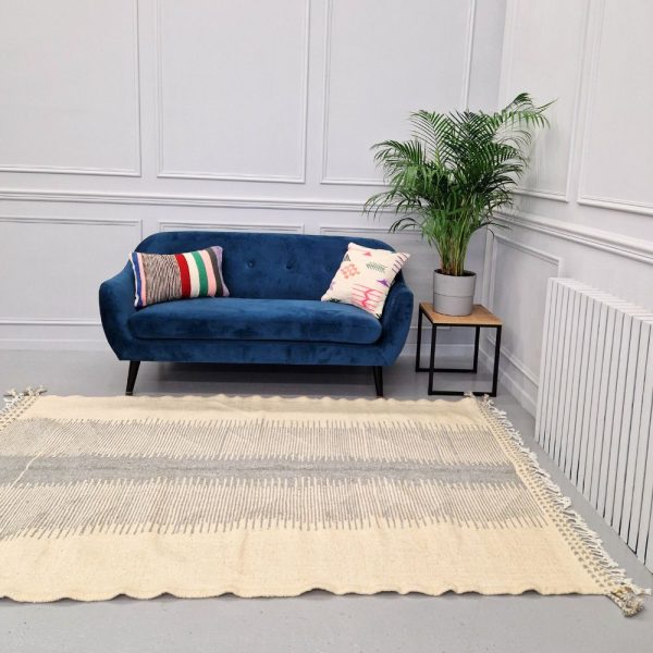 Minimalistic Moroccan Azilal rug with bold geometric patterns in white and blue wool, featuring abstract Berber tribal motifs and handwoven texture.