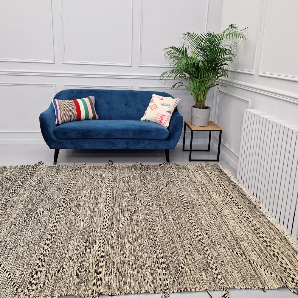 Minimalistic Moroccan Azilal rug with bold geometric patterns in white and black wool, featuring abstract Berber tribal motifs and handwoven texture.