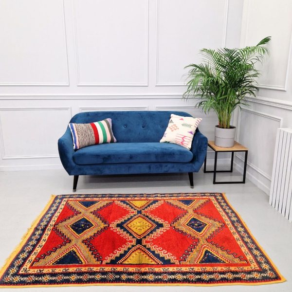 Colorful Moroccan Azilal rug with bold geometric patterns in red, orange, purple, and multicolor wool, featuring abstract Berber tribal motifs and handwoven texture.