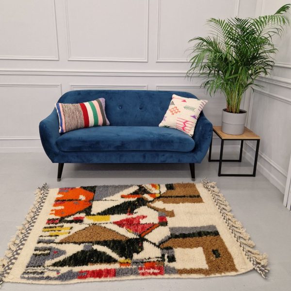 Colorful Moroccan Beni Ourain rug with blue, brown, red, black geometric patterns featuring abstract Berber tribal motifs and handwoven texture.