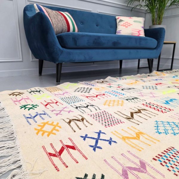 Colorful Moroccan Azilal rug with bold geometric patterns in red, orange, purple, and multicolor wool, featuring abstract Berber tribal motifs and handwoven texture.