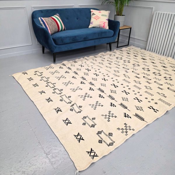 Minimalistic Moroccan Azilal rug with bold geometric patterns in white and black wool, featuring abstract Berber tribal motifs and handwoven texture.