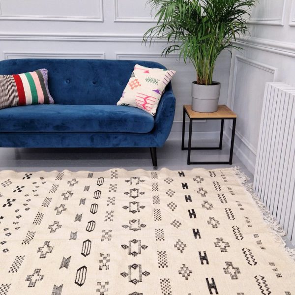 Minimalistic Moroccan Azilal rug with bold geometric patterns in white and black wool, featuring abstract Berber tribal motifs and handwoven texture.