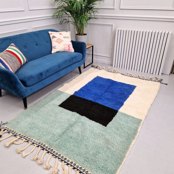 Colorful Moroccan Beni Ourain rug with blue, black and mint geometric patterns featuring abstract Berber tribal motifs and handwoven texture.