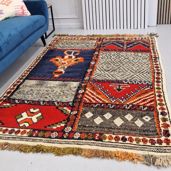 Colorful Moroccan Azilal rug with bold geometric patterns in red, blue, black, and multicolor wool, featuring abstract Berber tribal motifs and handwoven texture.