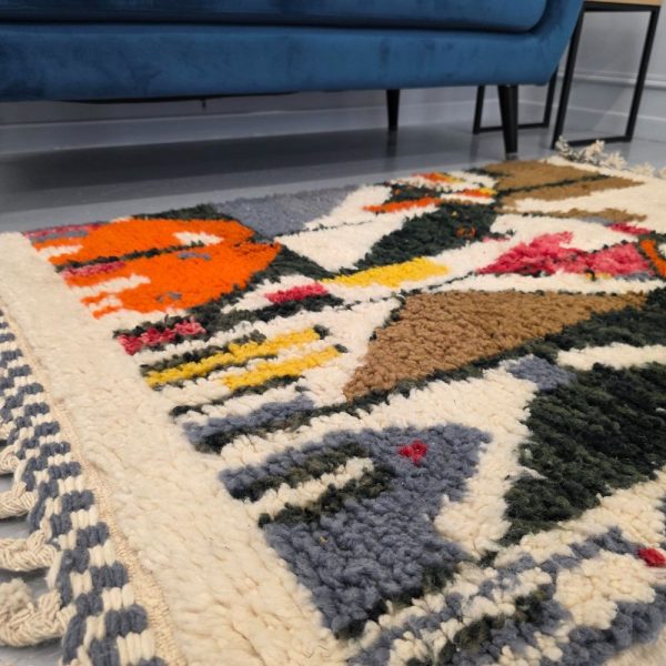Colorful Moroccan Beni Ourain rug with blue, brown, red, black geometric patterns featuring abstract Berber tribal motifs and handwoven texture.