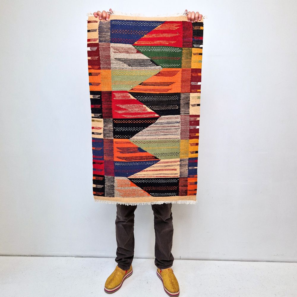 Bohemian Moroccan Azilal rug with bold geometric patterns in red, orange, purple, and multicolor wool, featuring abstract Berber tribal motifs and handwoven texture.