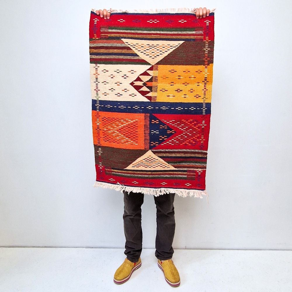 Bohemian Moroccan Azilal rug with bold geometric patterns in red, orange, purple, and multicolor wool, featuring abstract Berber tribal motifs and handwoven texture.