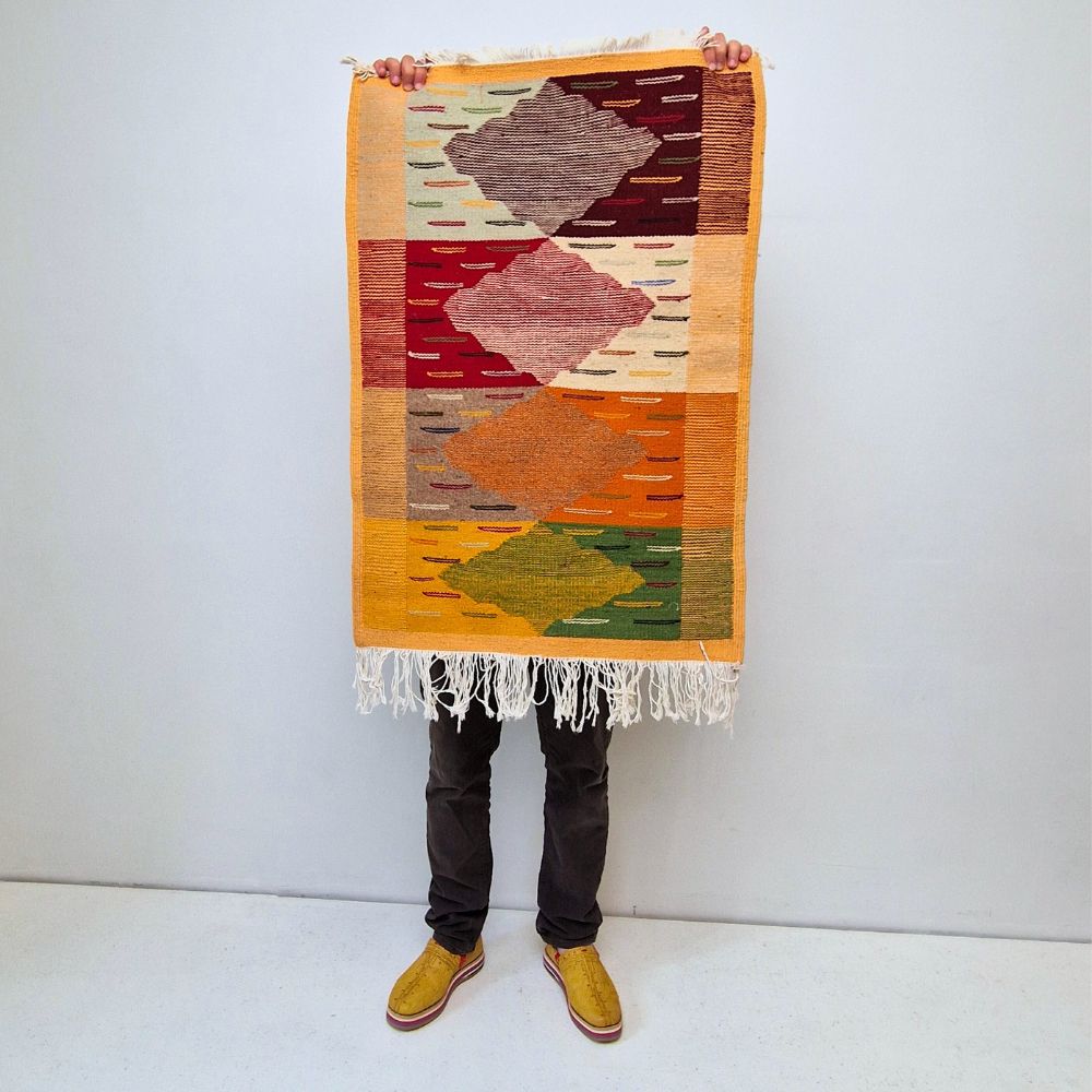 Bohemian Moroccan Azilal rug with bold geometric patterns in red, orange, purple, and multicolor wool, featuring abstract Berber tribal motifs and handwoven texture.