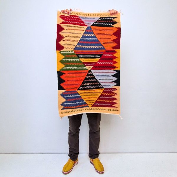 Colorful Moroccan Azilal rug with bold geometric patterns in red, orange, purple, and multicolor wool, featuring abstract Berber tribal motifs and handwoven texture.