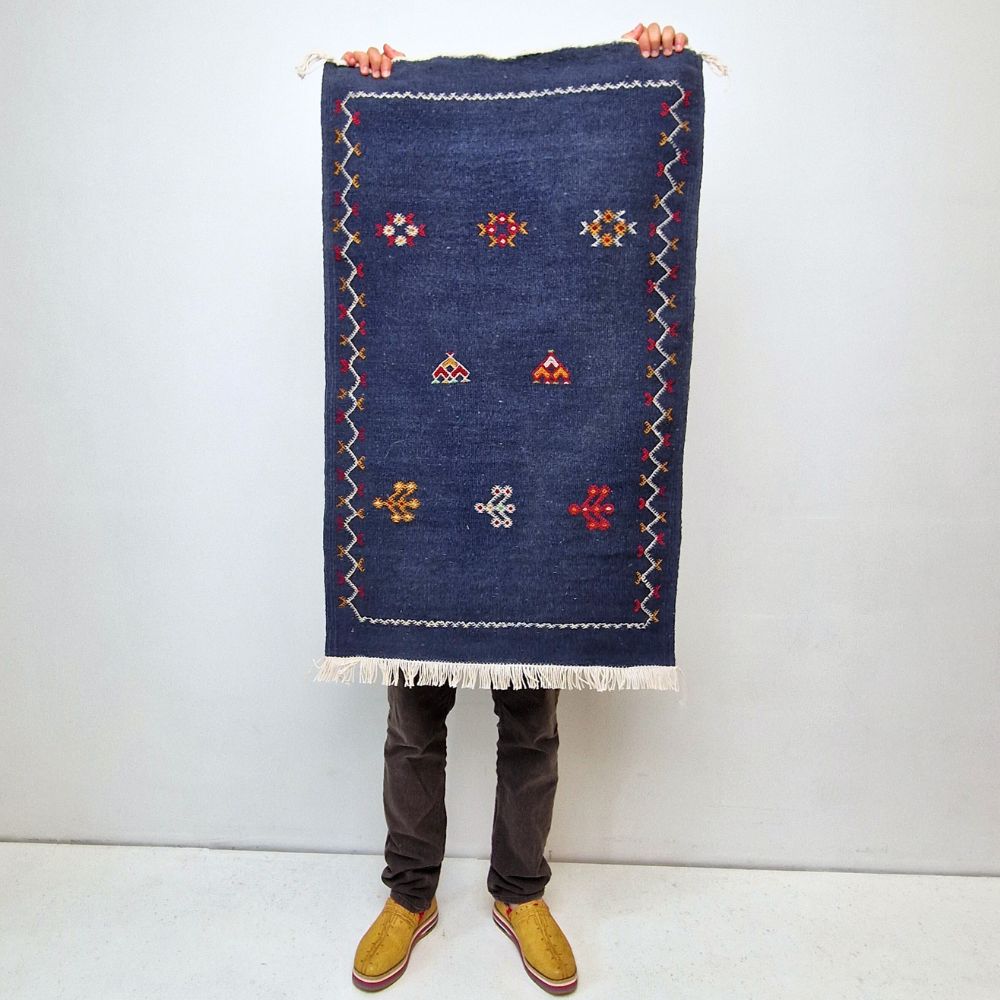 Colorful Moroccan Azilal rug with bold geometric patterns in red, orange, purple, and multicolor wool, featuring abstract Berber tribal motifs and handwoven texture.