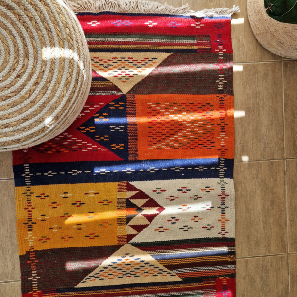 Bohemian Moroccan Azilal rug with bold geometric patterns in red, blue, white and multicolor wool, featuring abstract Berber tribal motifs and handwoven texture.
