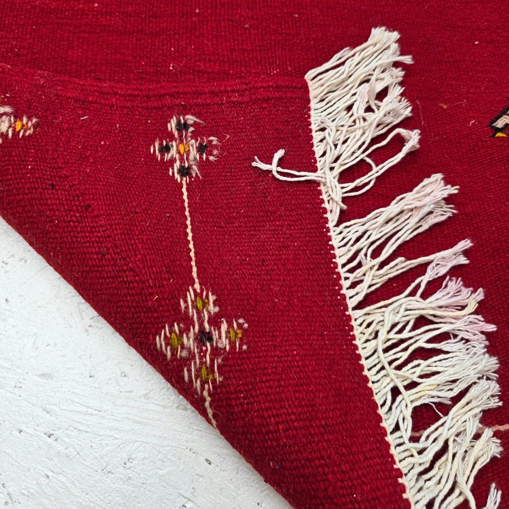 Bohemian Moroccan Azilal rug with bold geometric patterns in red, orange, purple, and multicolor wool, featuring abstract Berber tribal motifs and handwoven texture.