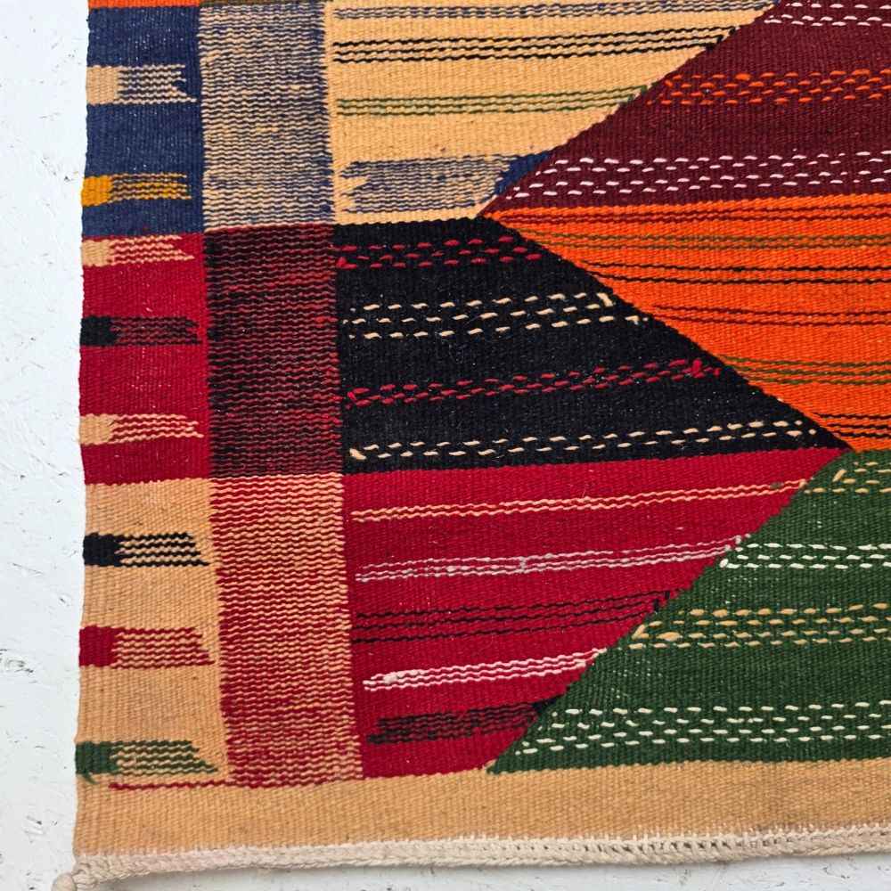 Bohemian Moroccan Azilal rug with bold geometric patterns in red, orange, purple, and multicolor wool, featuring abstract Berber tribal motifs and handwoven texture.