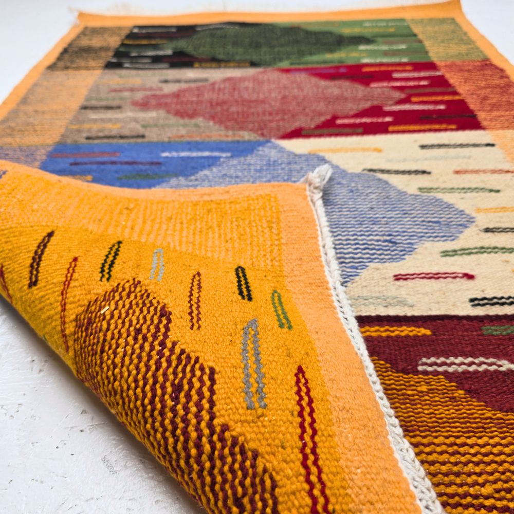 Bohemian Moroccan Azilal rug with bold geometric patterns in red, orange, purple, and multicolor wool, featuring abstract Berber tribal motifs and handwoven texture.