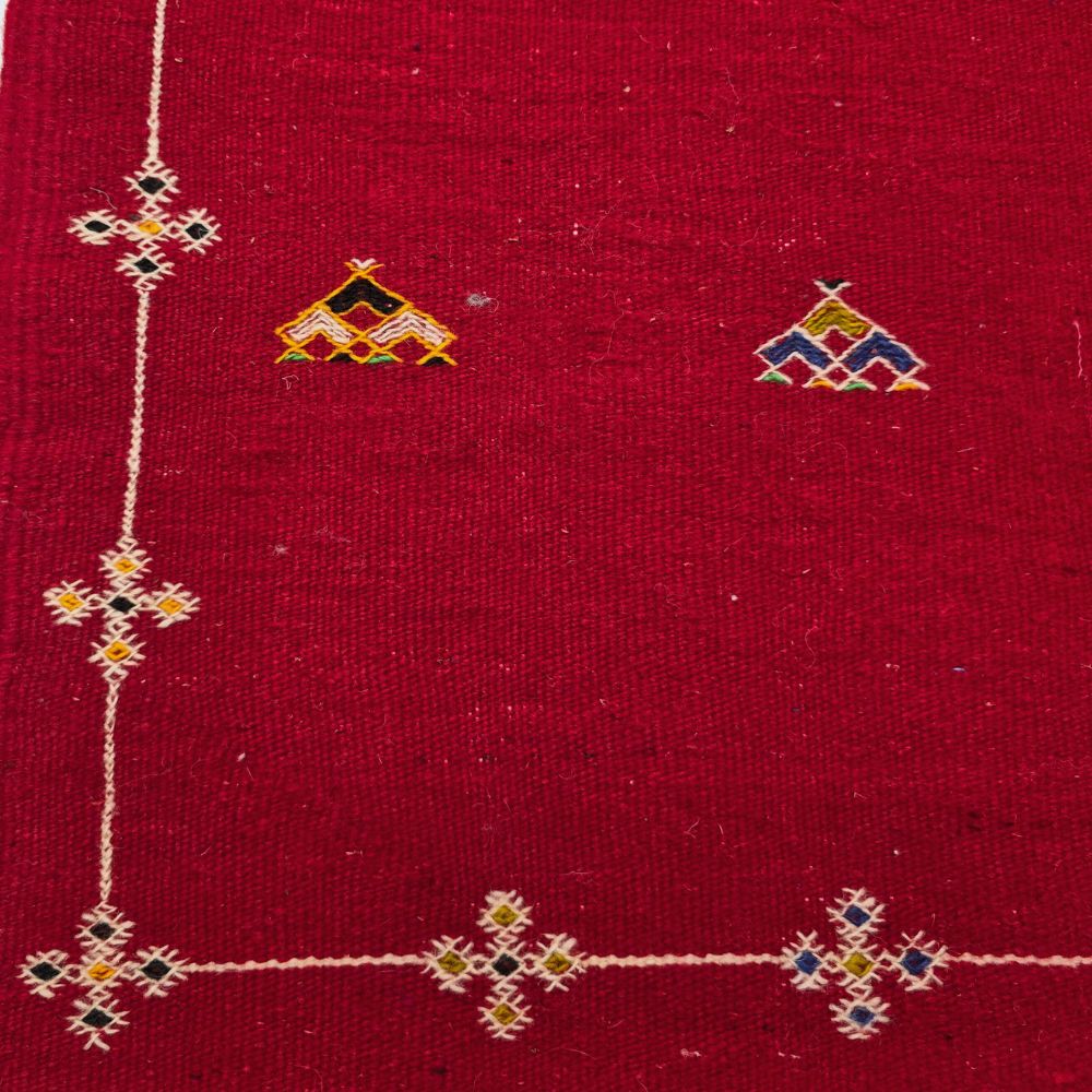 Bohemian Moroccan Azilal rug with bold geometric patterns in red, orange, purple, and multicolor wool, featuring abstract Berber tribal motifs and handwoven texture.