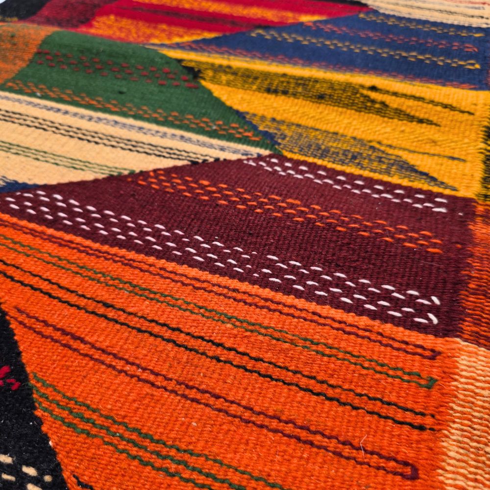 Bohemian Moroccan Azilal rug with bold geometric patterns in red, orange, purple, and multicolor wool, featuring abstract Berber tribal motifs and handwoven texture.
