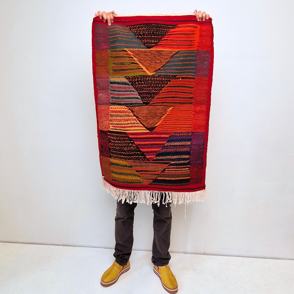 Bohemian Moroccan Azilal rug with bold geometric patterns in red, orange, purple, and multicolor wool, featuring abstract Berber tribal motifs and handwoven texture.