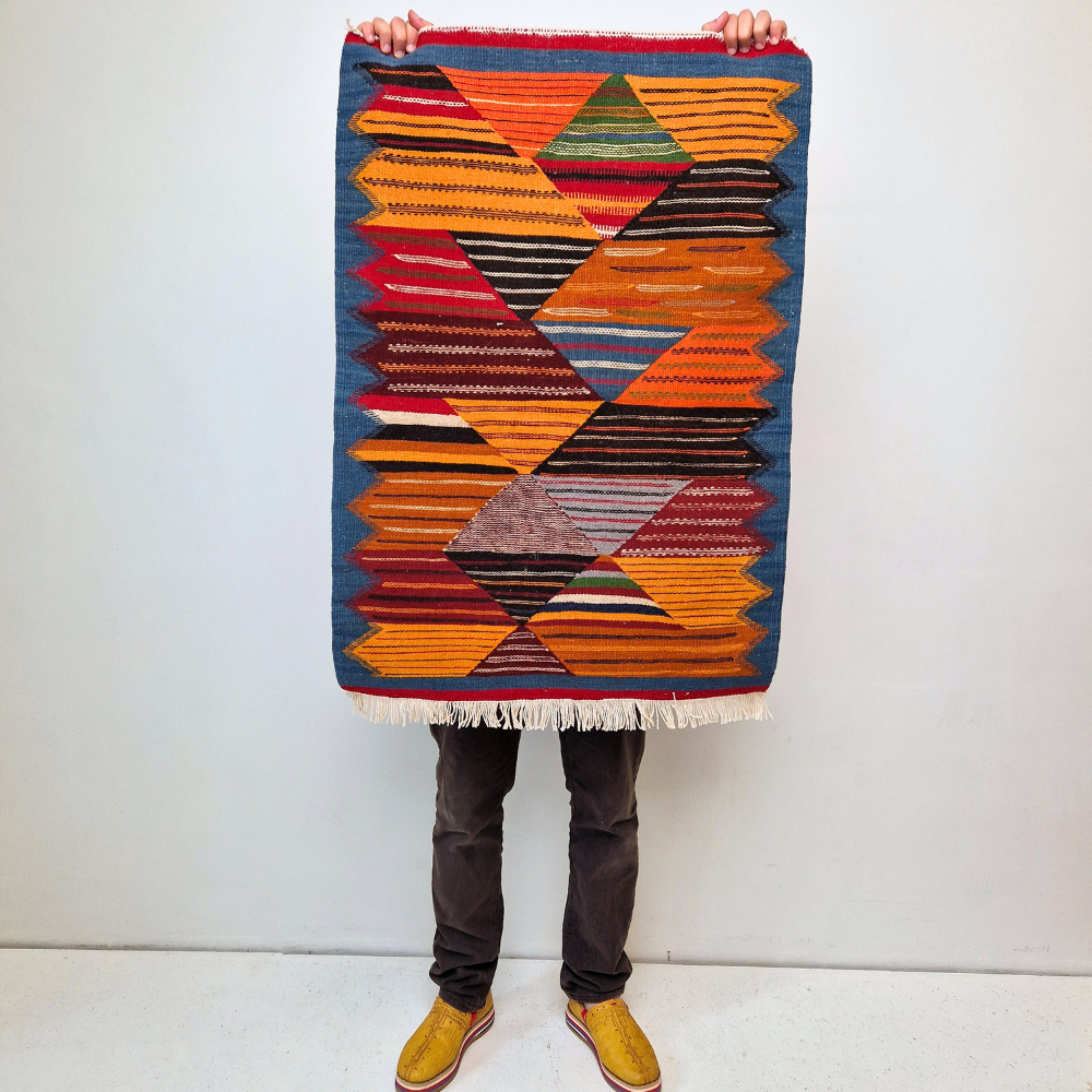 Bohemian Moroccan Azilal rug with bold geometric patterns in red, orange, purple, and multicolor wool, featuring abstract Berber tribal motifs and handwoven texture.