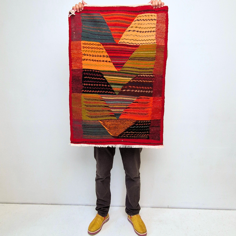 Bohemian Moroccan Azilal rug with bold geometric patterns in red, orange, purple, and multicolor wool, featuring abstract Berber tribal motifs and handwoven texture.