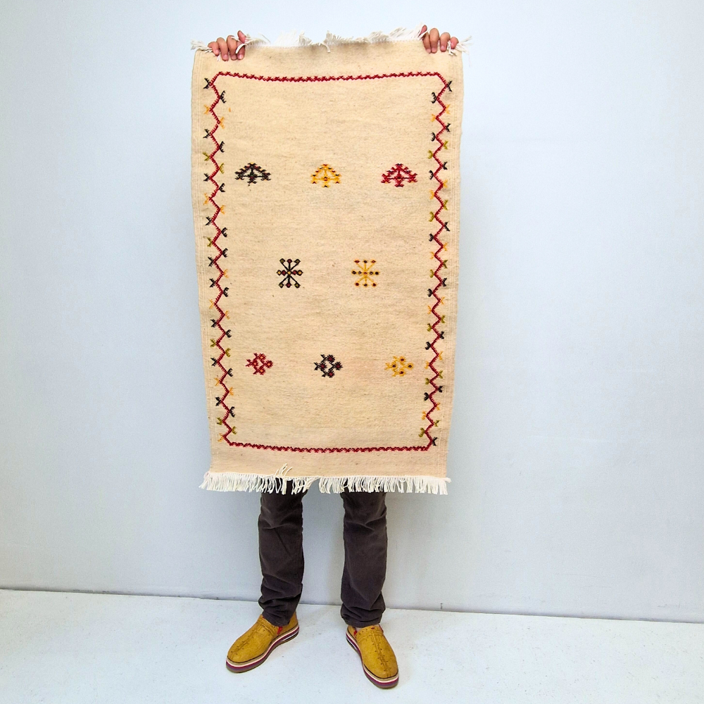 Bohemian Moroccan Azilal rug with bold geometric patterns in red, orange, purple, and multicolor wool, featuring abstract Berber tribal motifs and handwoven texture.