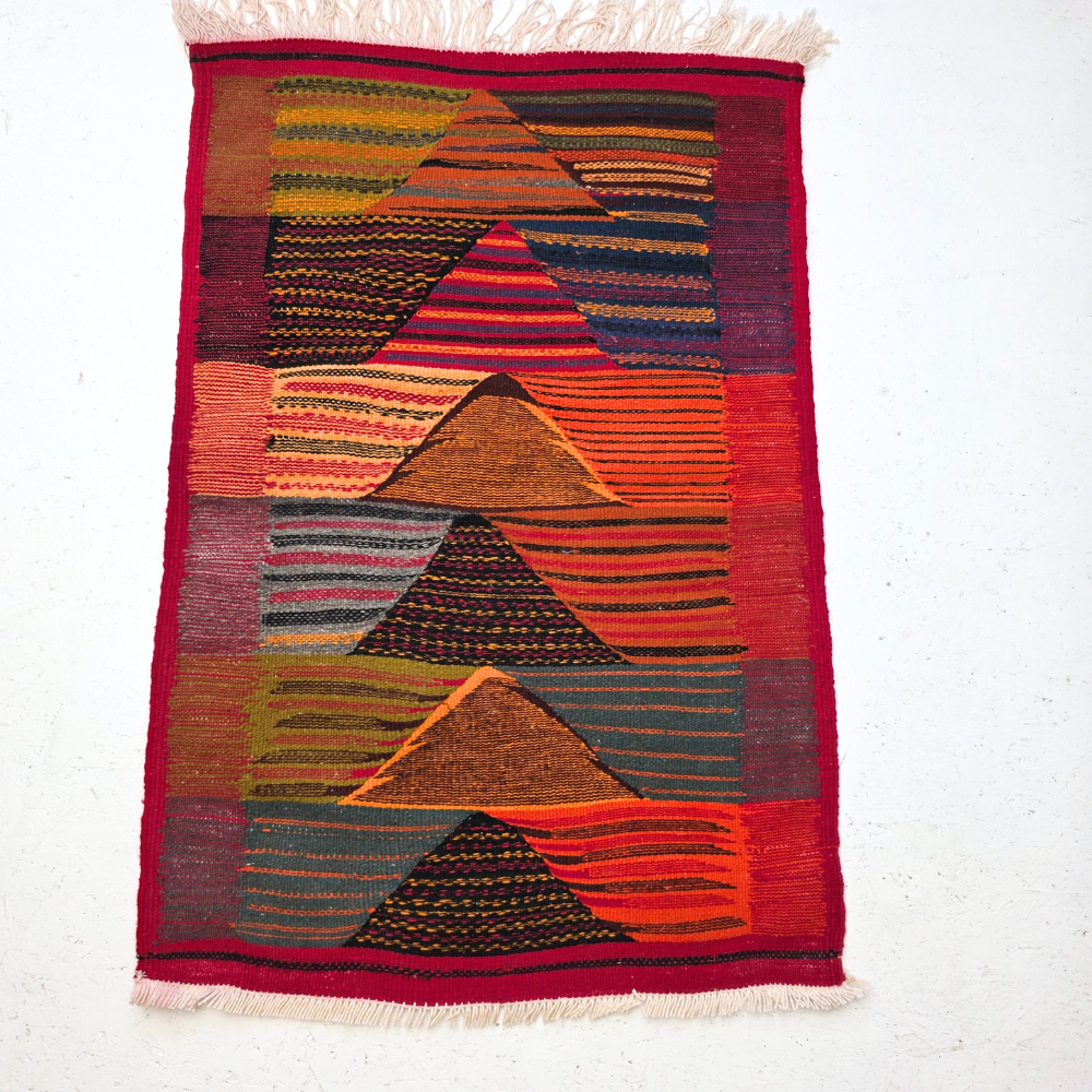 Bohemian Moroccan Azilal rug with bold geometric patterns in red, orange, purple, and multicolor wool, featuring abstract Berber tribal motifs and handwoven texture.