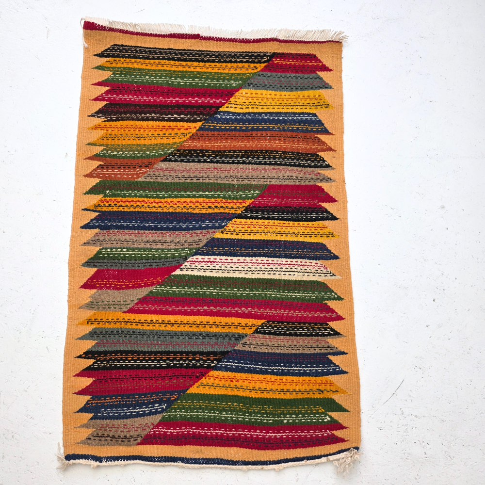 Bohemian Moroccan Azilal rug with bold geometric patterns in red, orange, purple, and multicolor wool, featuring abstract Berber tribal motifs and handwoven texture.